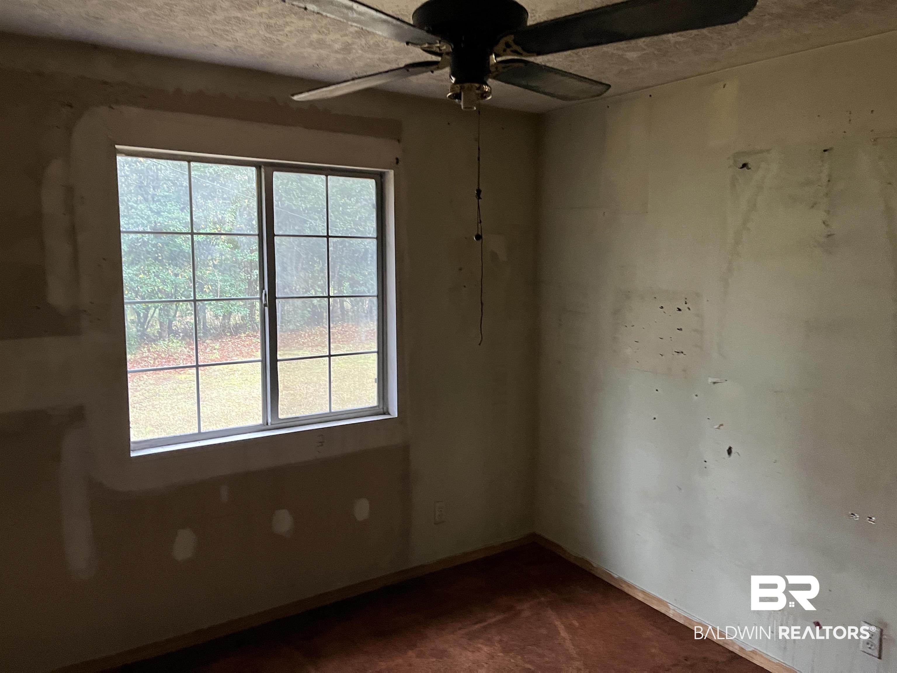 127 Moore Street Brewton, AL 36426 - Photo 11 of 15 Spare room with baseboards, a textured ceiling, and a ceiling fan