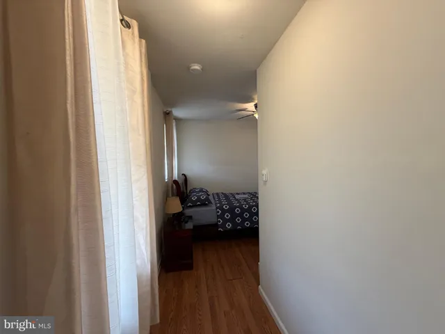 a view of a hallway with a livingroom and a hallway with wooden floor