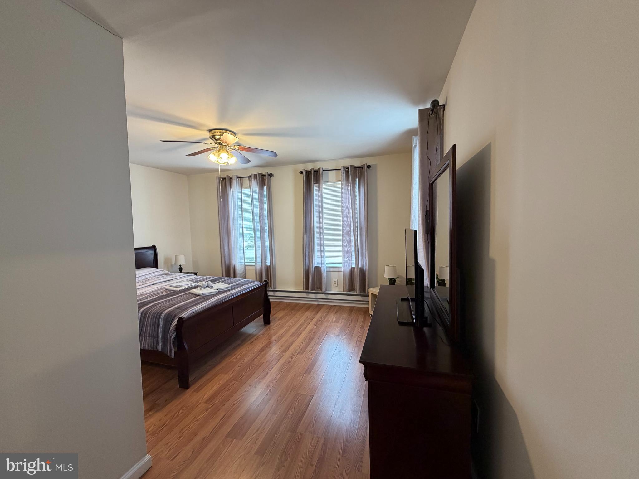 7103 Rising Sun Avenue, Unit C Philadelphia, PA 19111 - Photo 9 of 19 a bedroom with a bed and a chandelier