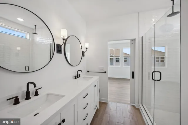 a bathroom with a double vanity sink mirror and shower