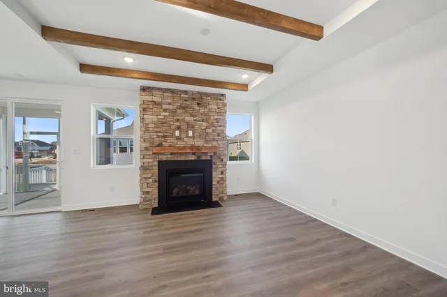 a view of empty room with wooden floor and fireplace