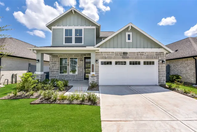 a front view of a house with a yard and potted plants