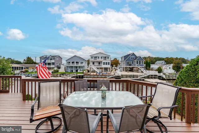 a view of a patio with table and chairs with wooden floor and fence