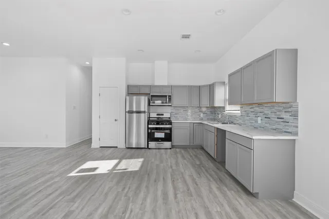 a view of kitchen and hall with wooden floor