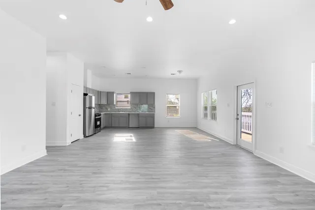 a view of empty room with wooden floor and window