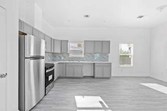 a kitchen with granite countertop a refrigerator stove top oven and sink
