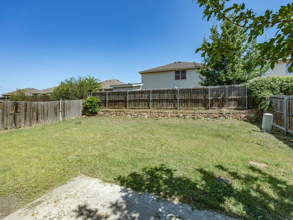 2021 Laughlin Road Fort Worth, TX 76177 - Photo 40 of 40 Fenced backyard with a stone retaining wall and concrete patio area