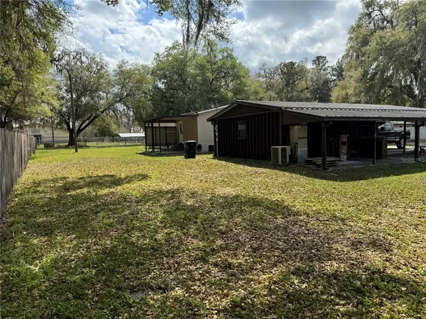 a view of a house with a yard and sitting area