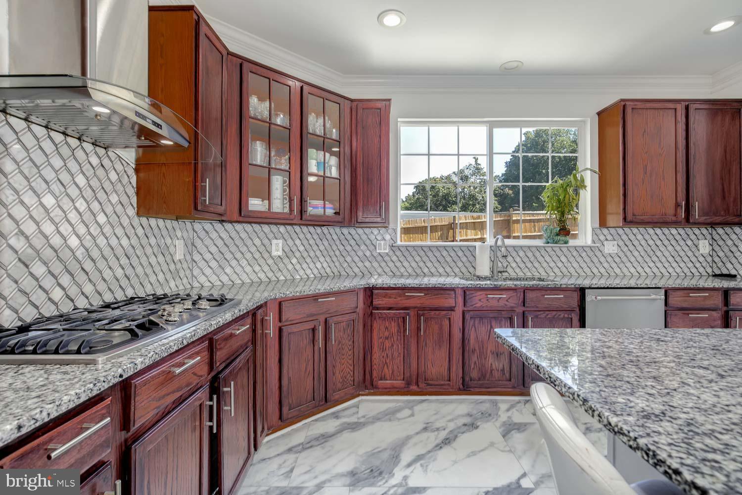 6810 Ashleys Crossing Court Temple Hills, MD 20748 - Photo 15 of 45 a kitchen with stainless steel appliances granite countertop a stove sink and cabinets