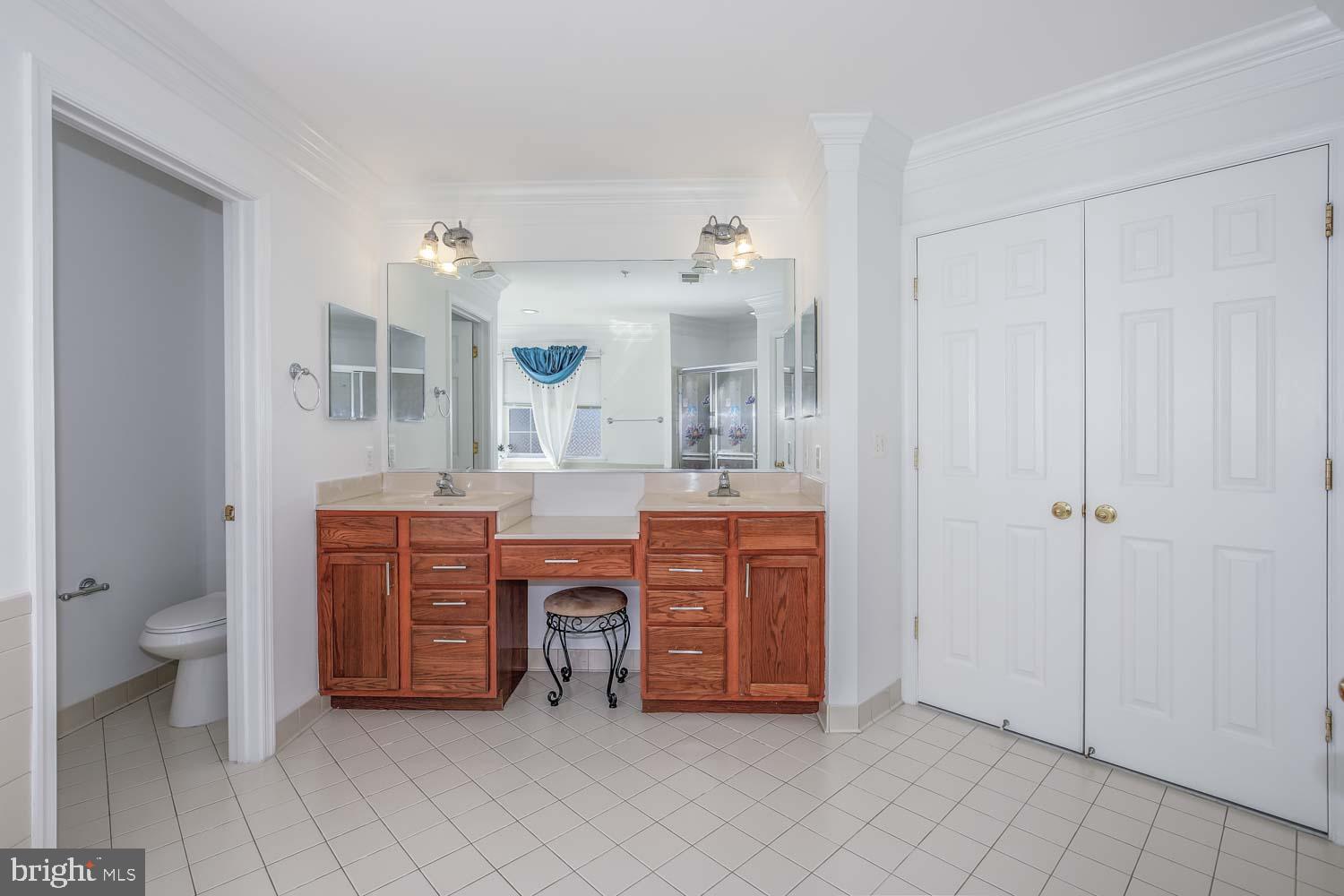 6810 Ashleys Crossing Court Temple Hills, MD 20748 - Photo 24 of 45 a spacious bathroom with a granite countertop sink toilet and a mirror