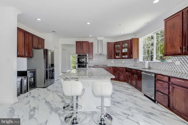 a kitchen with stainless steel appliances granite countertop a stove a sink a microwave cabinets and a dining table