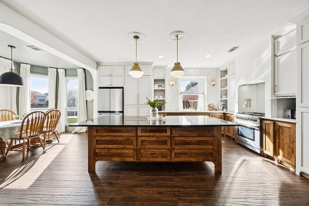 a large kitchen with granite countertop lots of counter space and windows