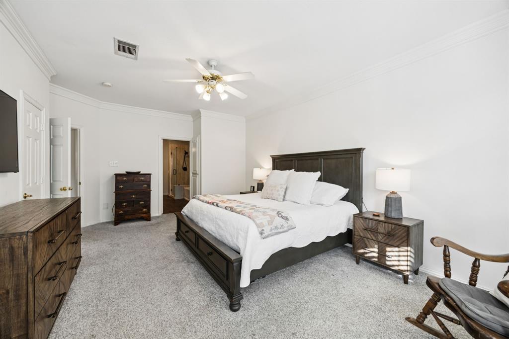 902 Kilgore Court Allen, TX 75013 - Photo 14 of 32 a spacious bedroom with a bed a dresser and a chandelier