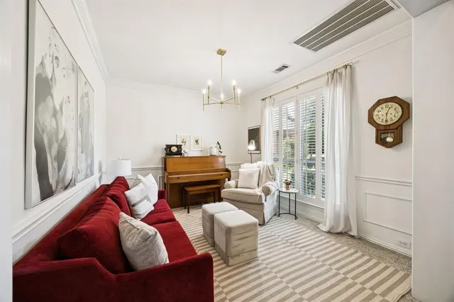 a living room with furniture a fireplace and a chandelier
