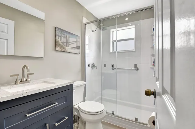 a bedroom with a bed a chandelier and flat screen tv