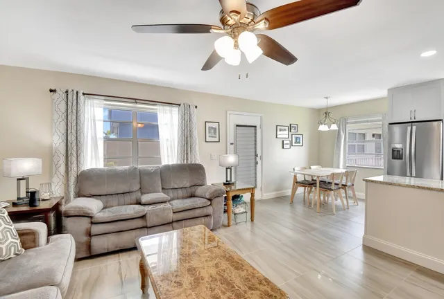 a kitchen with stainless steel appliances kitchen island granite countertop a table chairs and a refrigerator