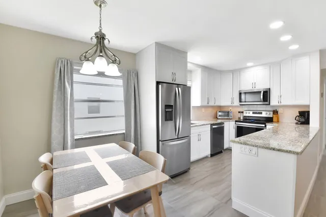 a kitchen with stainless steel appliances granite countertop a refrigerator sink and stove
