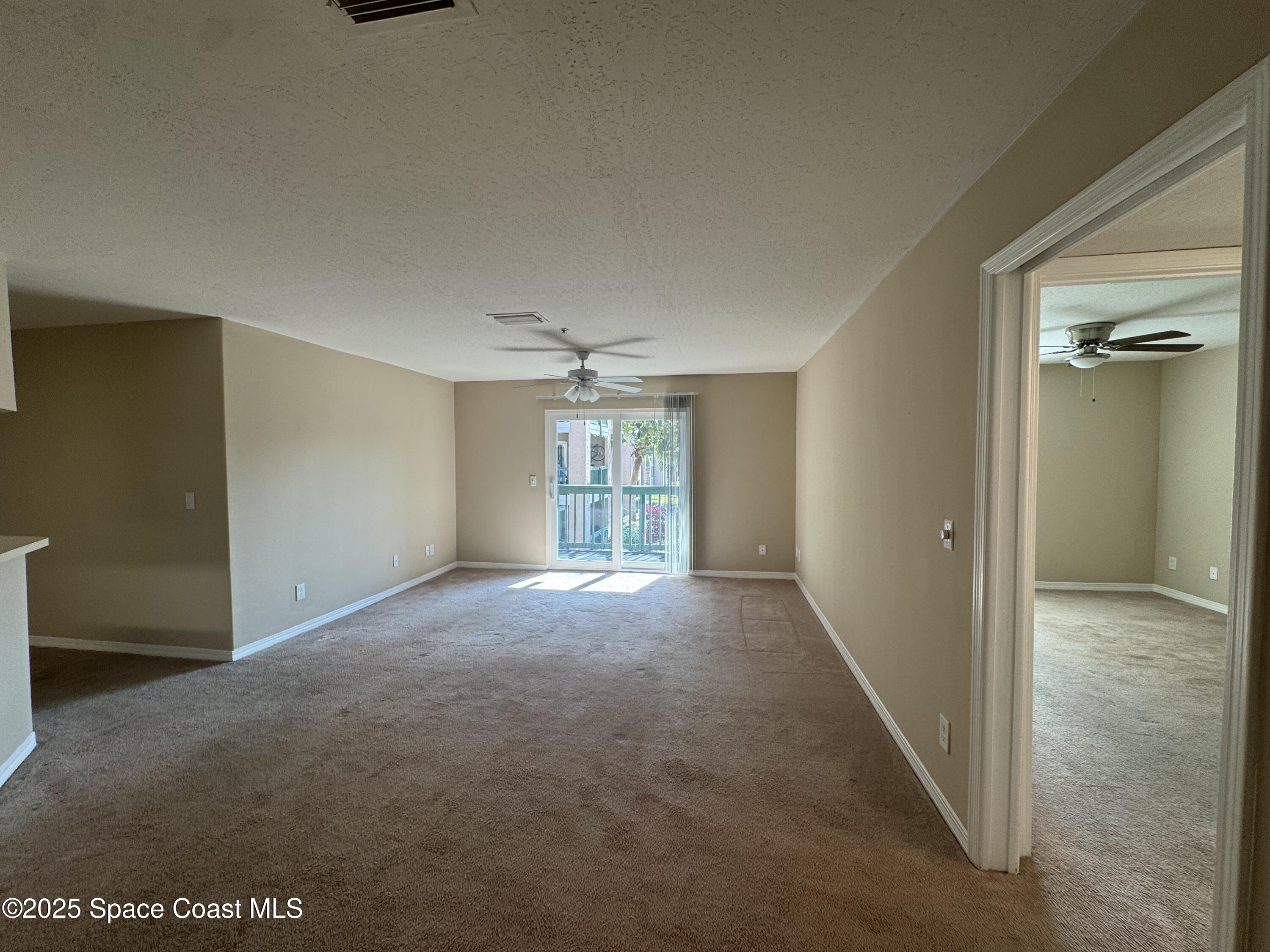 7667 North Wickham Road, Unit 1013 Melbourne, FL 32940 - Photo 3 of 14 an empty room with windows and cabinet