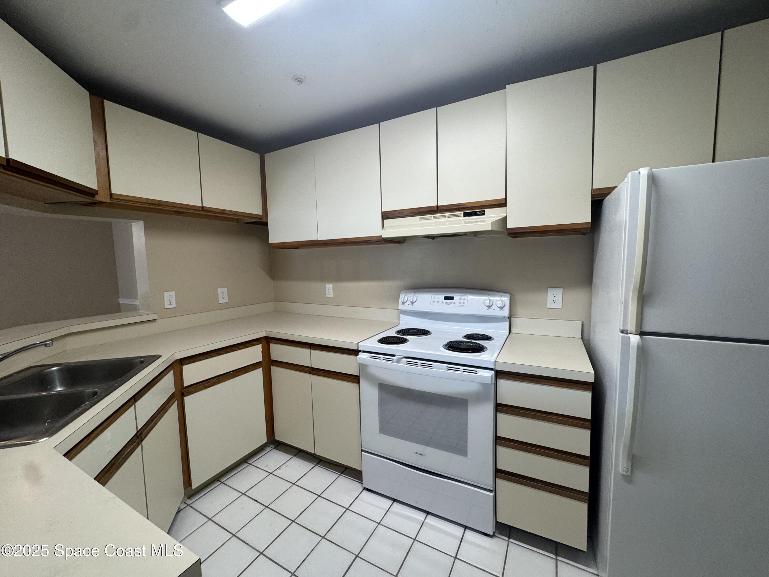 7667 North Wickham Road, Unit 1013 Melbourne, FL 32940 - Photo 6 of 14 a kitchen with cabinets stainless steel appliances and a sink