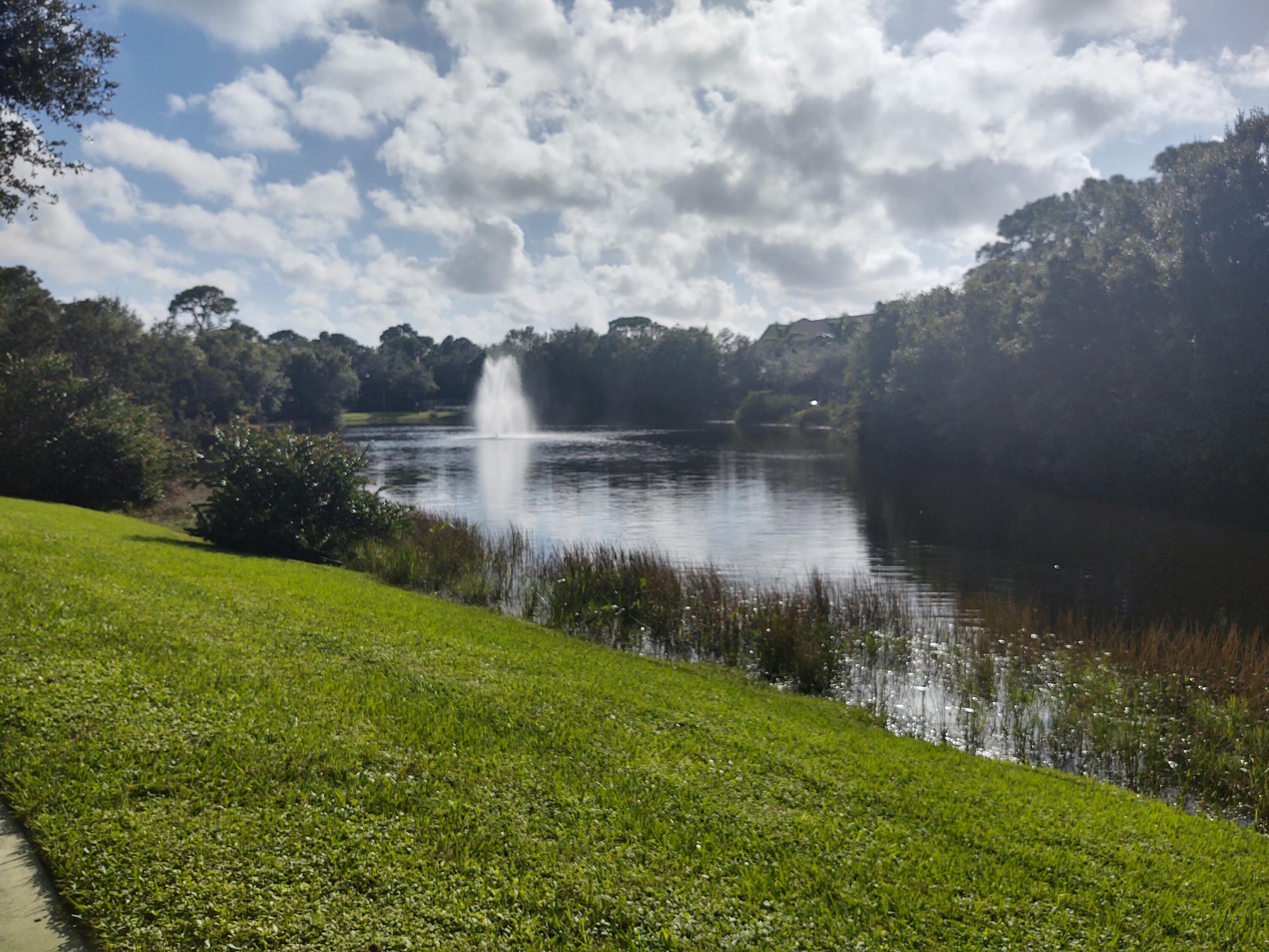 265 Indian Creek Parkway, Unit 102 Jupiter, FL 33458 - Photo 20 of 21 a view of a lake with a yard
