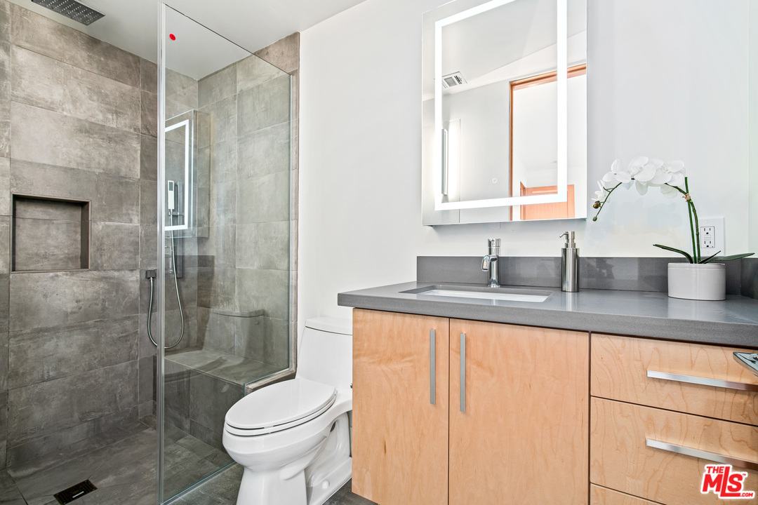 11519 Mississippi Avenue Los Angeles, CA 90025 - Photo 41 of 45 a bathroom with a granite countertop sink toilet and shower