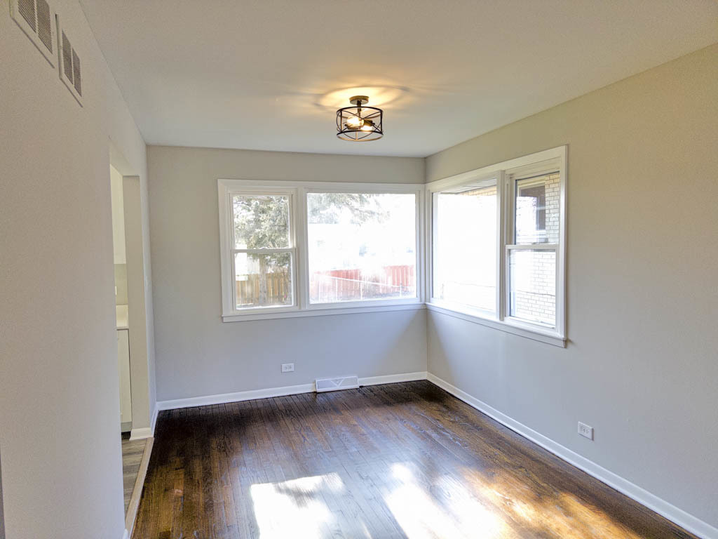 5633 Murray Drive Berkeley, IL 60163 - Photo 5 of 17 a view of an empty room with a window and wooden floor