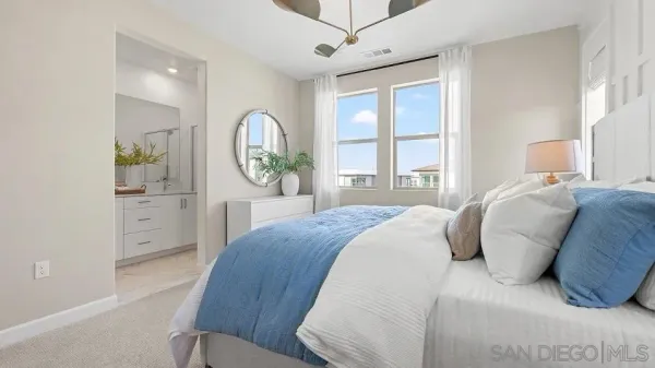 a bedroom with a bed mirror dresser and a window