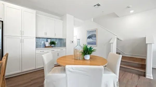a kitchen with white cabinets and wooden floor
