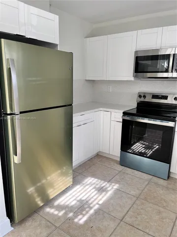 a white refrigerator freezer and a stove sitting inside of a kitchen