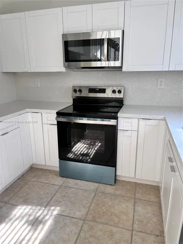 a kitchen with stainless steel appliances a stove a microwave and cabinets