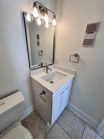 a bathroom with a sink vanity and toilet