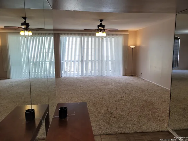 an empty room with stairs and wooden floor