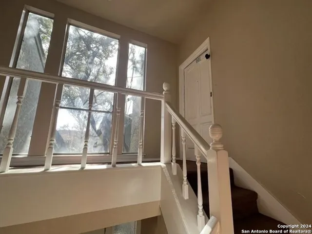 a view of an empty room with a chandelier fan