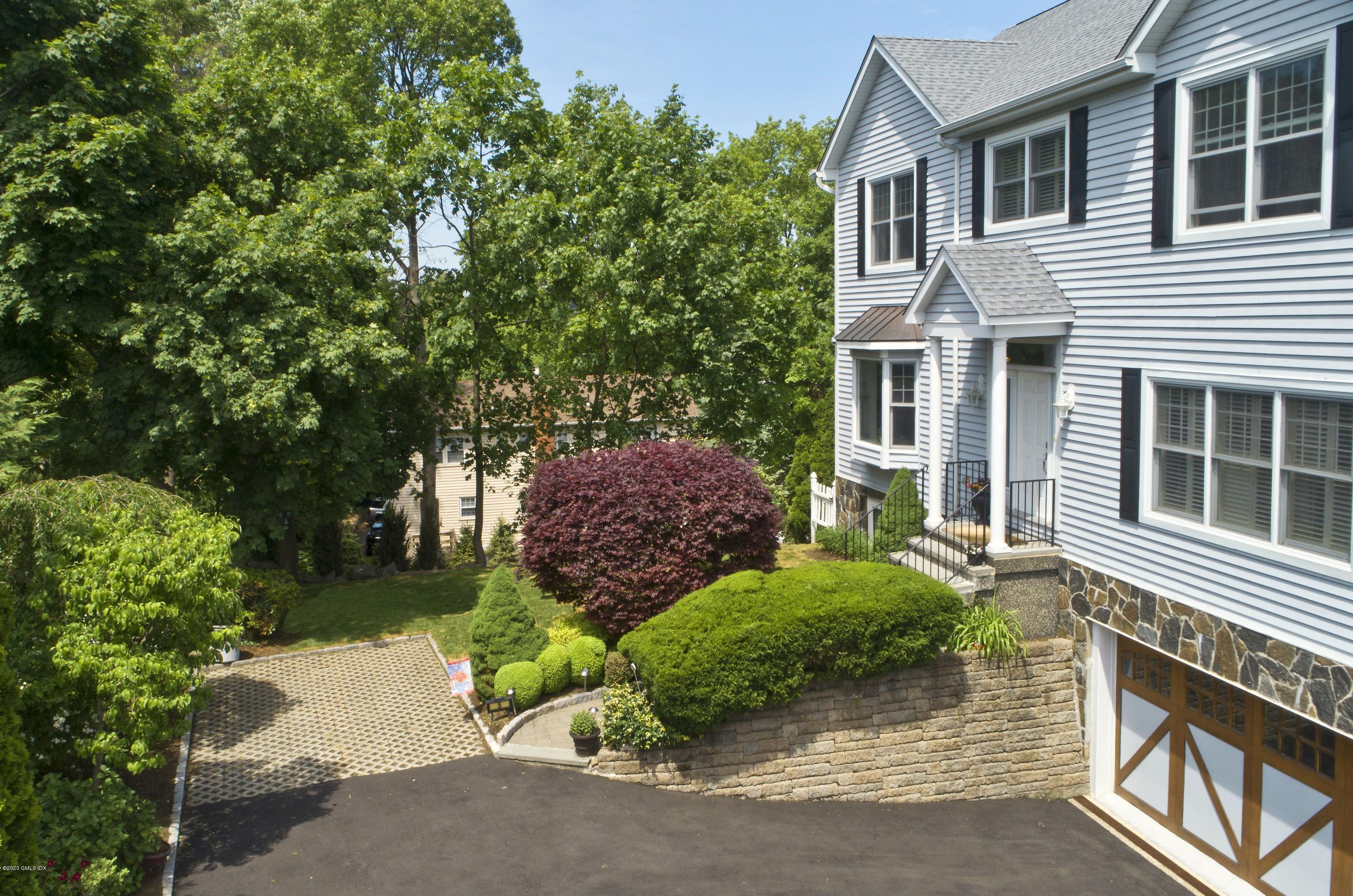 8 View Street, Unit 5 Greenwich, CT 06830 - Photo 5 of 30 a view of a house with a small yard and plants