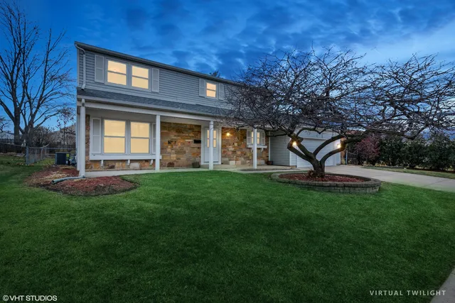 a front view of a house with a garden and yard