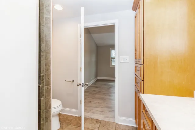 a bathroom with a granite countertop toilet and a sink