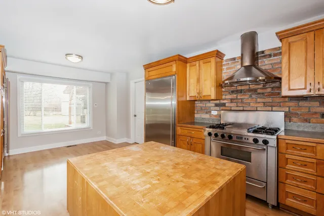 a kitchen with stainless steel appliances granite countertop a stove a sink and a refrigerator