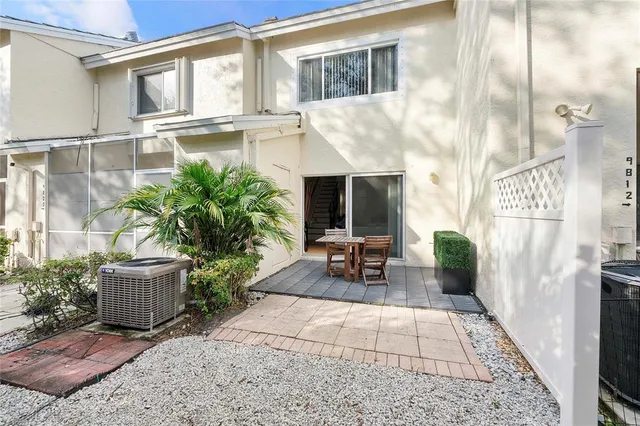 a view of a porch with chairs and potted plants
