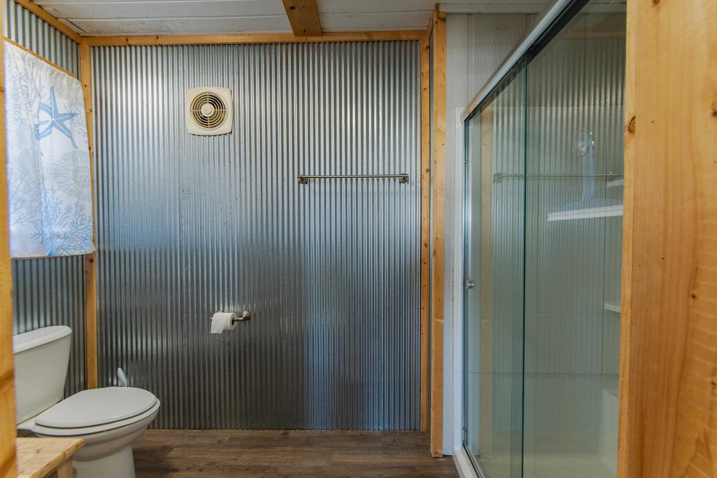 1111 Leaning Trees Lane Adamsville, TN 38310 - Photo 23 of 36 Bathroom with a shower with shower door, toilet, and wood-type flooring