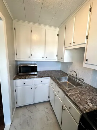 a kitchen with granite countertop a sink and a stove