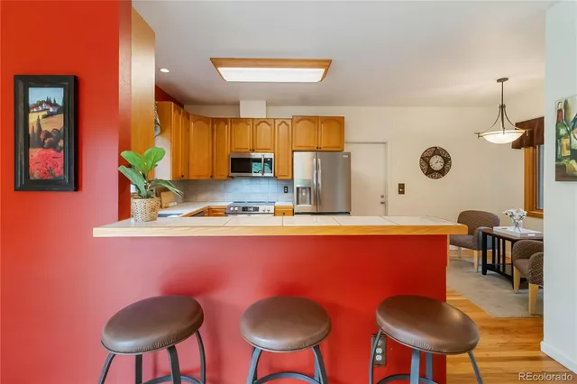 a kitchen with stainless steel appliances granite countertop a sink and a refrigerator
