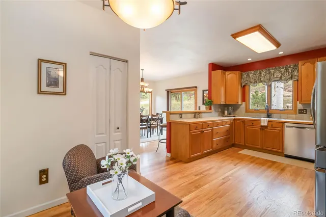 a kitchen with stainless steel appliances granite countertop a refrigerator a sink dishwasher a stove with wooden cabinets and floor