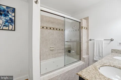 a bathroom with a granite countertop sink mirror and shower