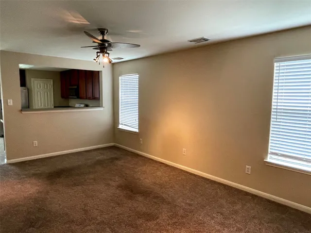 an empty room with windows and cabinet