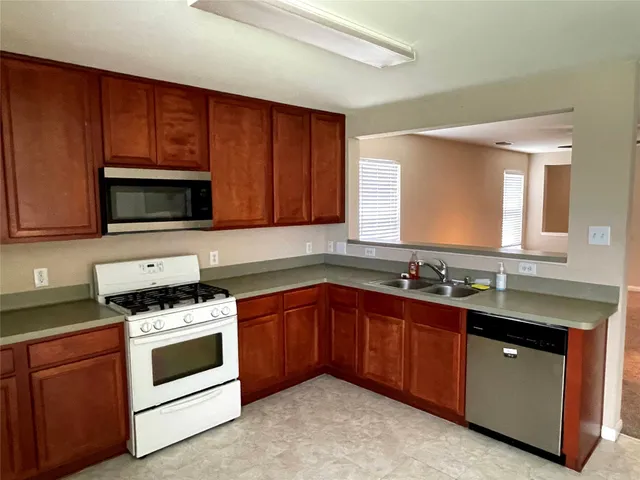 a kitchen with sink cabinets and stainless steel appliances