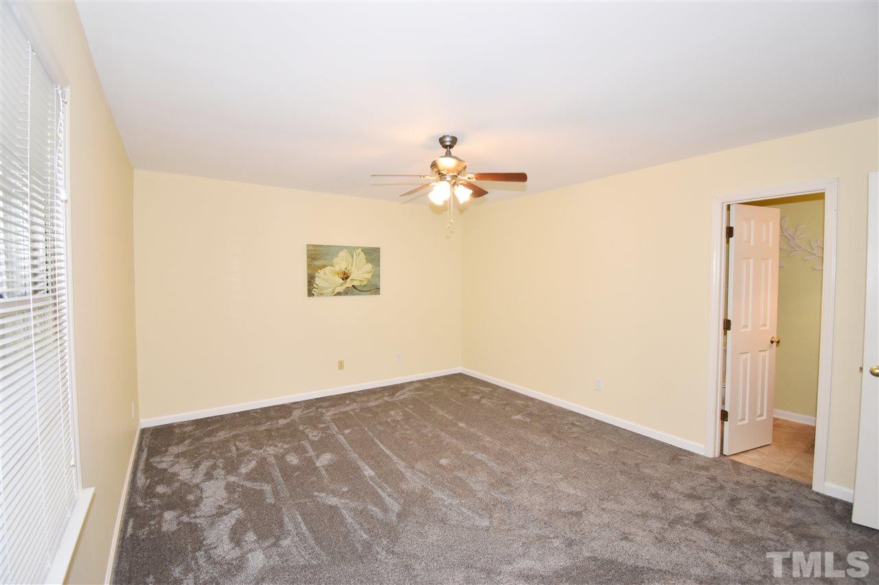 6710 Twin Tree Court Raleigh, NC 27613 - Photo 12 of 18 an empty room with a window and a ceiling fan