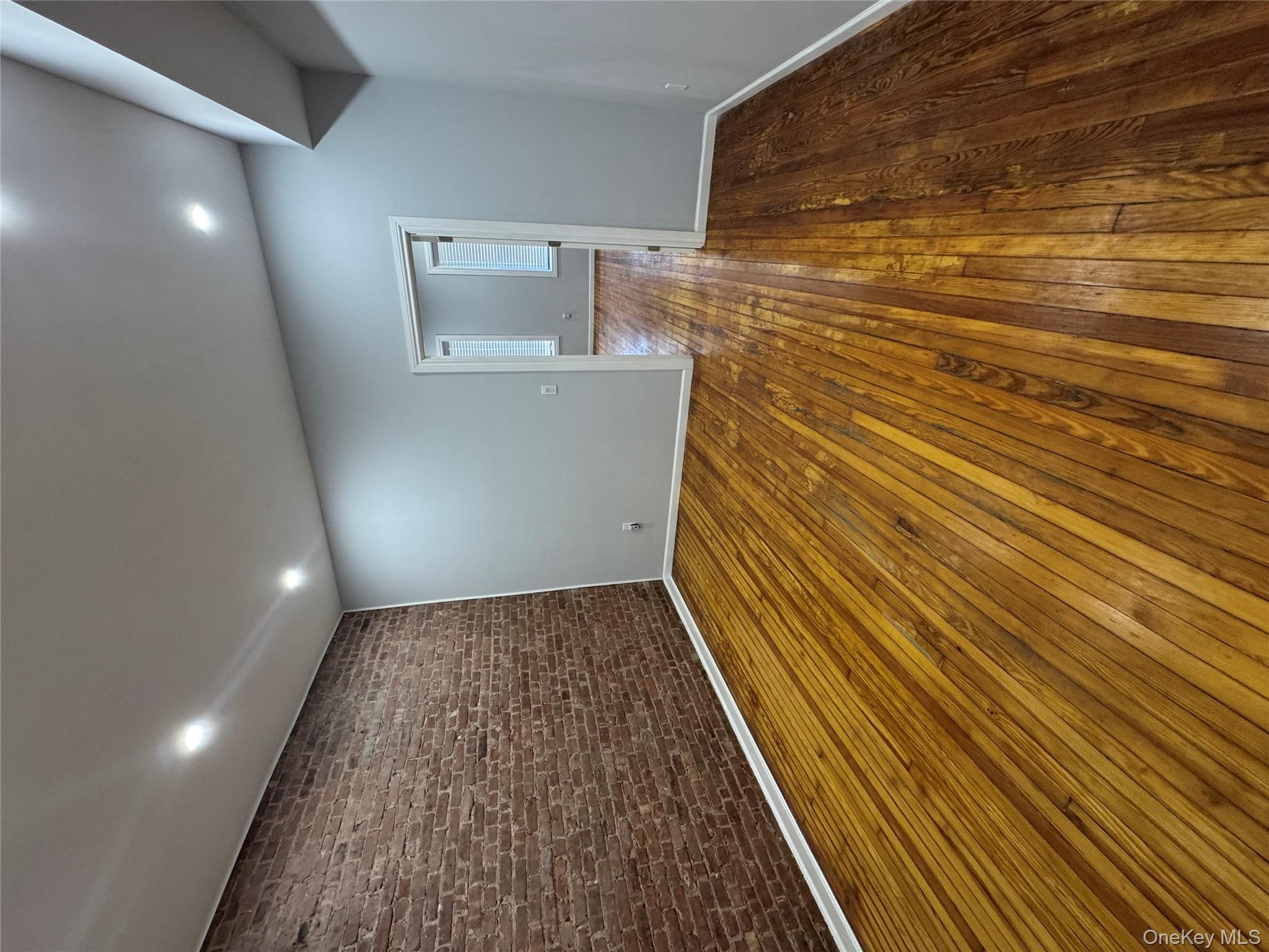 299 Malcolm X Boulevard Brooklyn, NY 11233 - Photo 4 of 9 a view of empty room with wooden floor