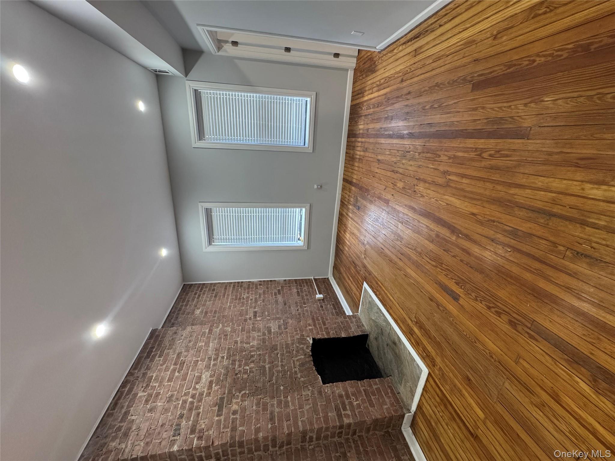 299 Malcolm X Boulevard Brooklyn, NY 11233 - Photo 6 of 9 a view of empty room with wooden floor and fireplace