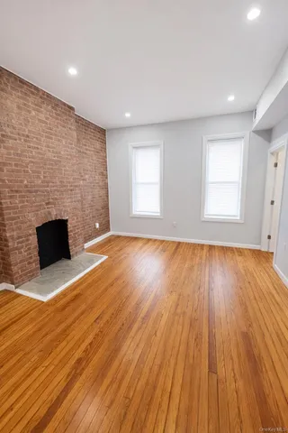 an empty room with wooden floor and fireplace