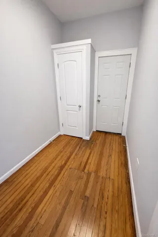 a view of a room with wooden floor and white walls